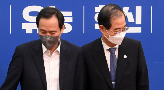 우상호 더불어민주당 비상대책위원장이 20일 서울 여의도 국회 대표실을 방문한 한덕수 국무총리와 인사한 뒤 자리에 앉고 있다. 국회사진기자단=연합뉴스.